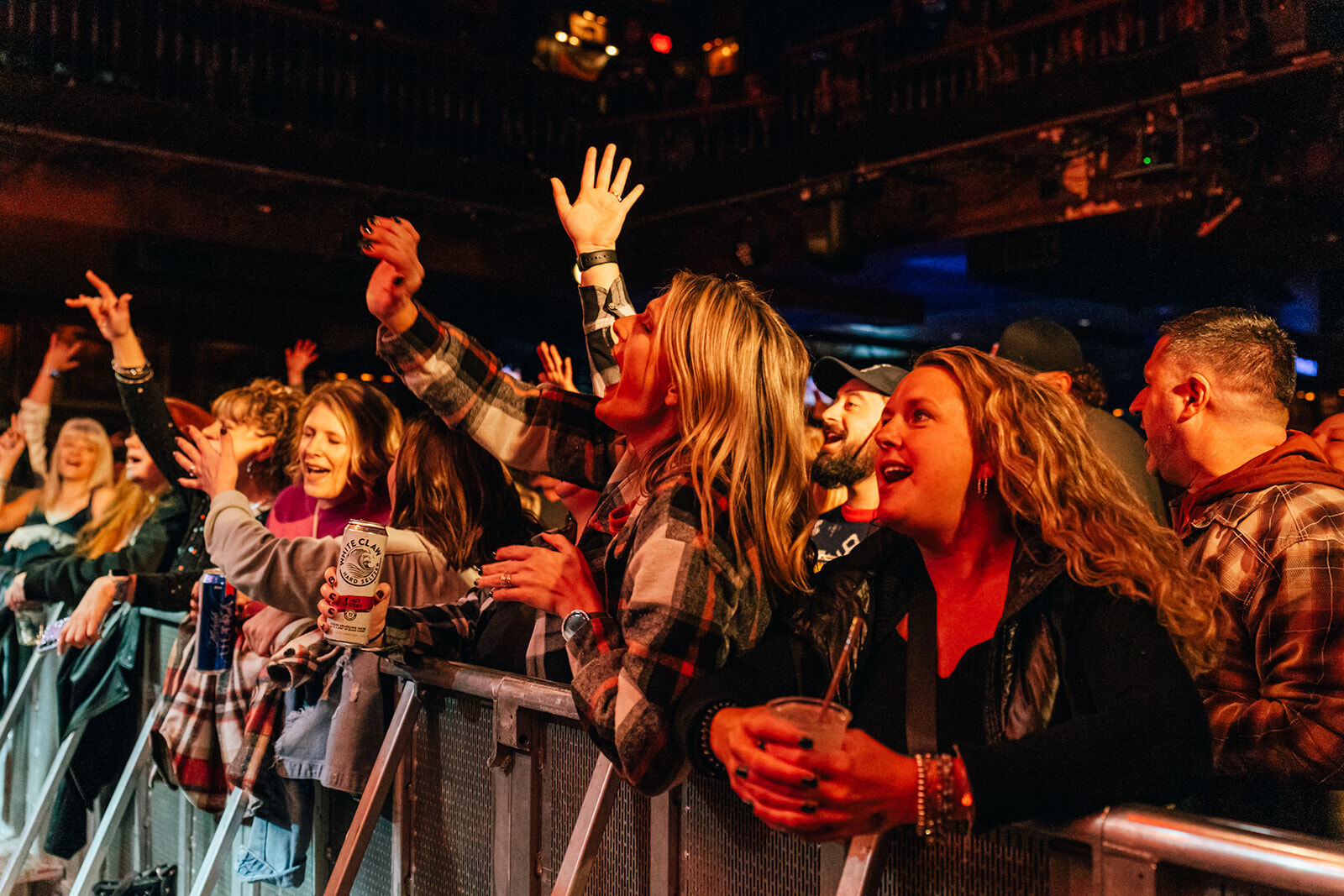 Fans at the barricade singing with their hands in the air